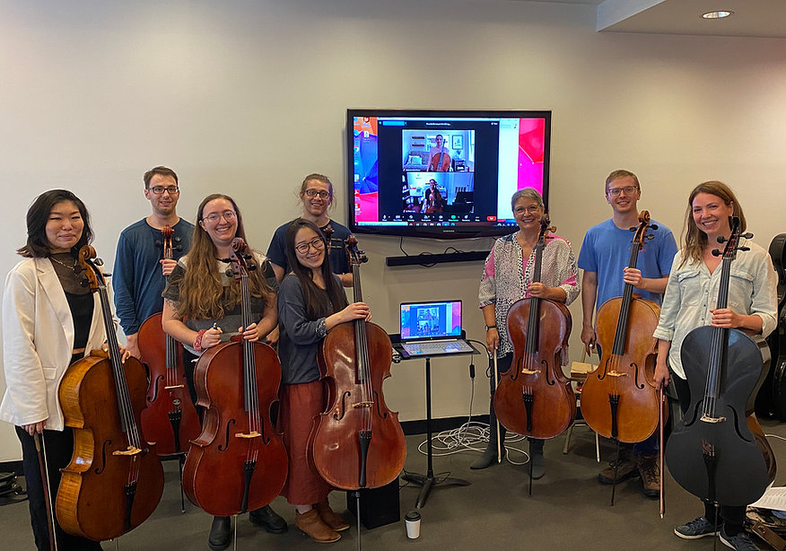 Erica with a group of her students, all standing with cellos